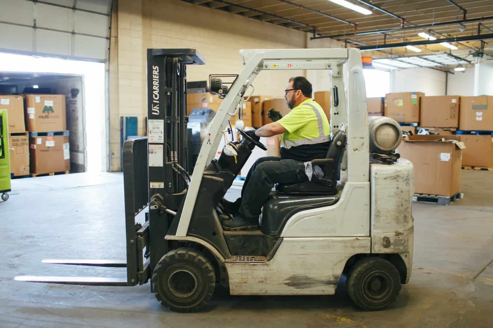 Certified recycler Repowered employs safety practices in its warehouse with forklift driver moving load of boxes 