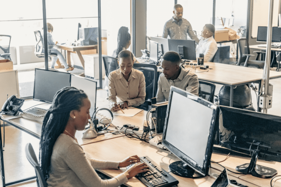 wholesale technology at work, showing a professional office with work stations and team members interacting