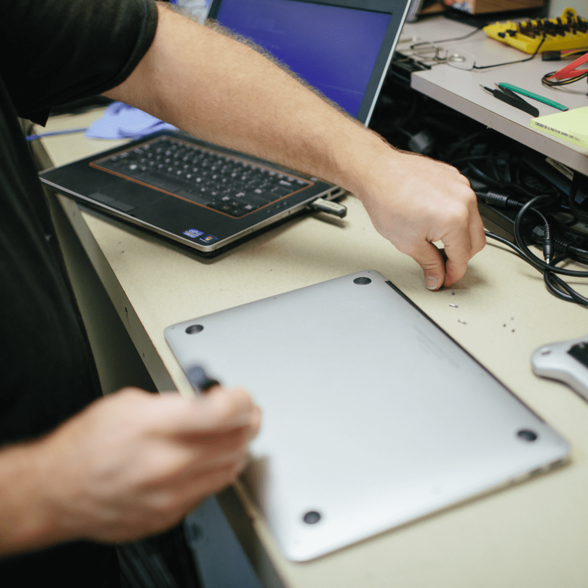 Close up of hands repairing a laptop