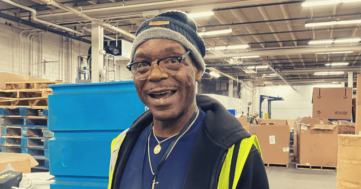 Grant in the warehouse, smiling at the camera